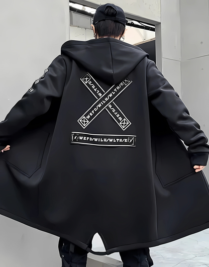 Person wearing a black coat with a large logo on the back, standing in an urban setting.