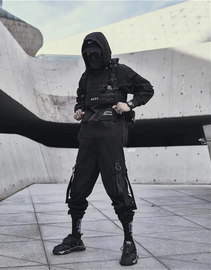 Person wearing a black outfit with tactical gear in an urban setting