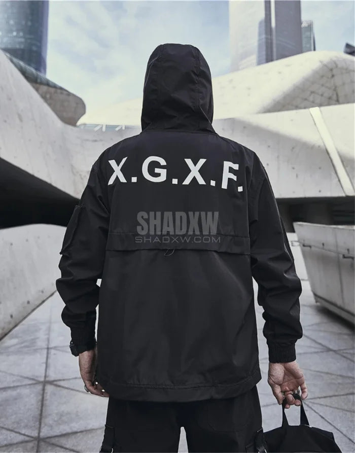 Person wearing a black jacket with 'X.G.X.F.' branding in an urban setting